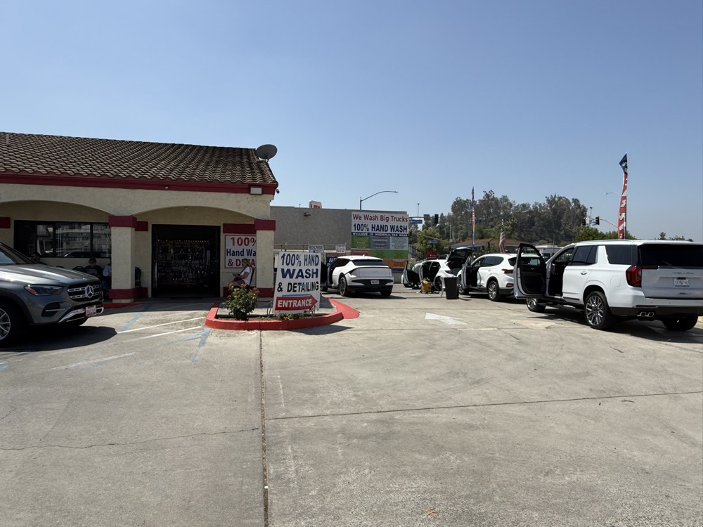 Magnolia Car Wash entrance and lot — 100% hand wash & detailing, cars being serviced